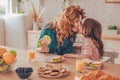Daughter and mother having breakfast and touching noses on the domestic kitchen Royalty Free Stock Photo