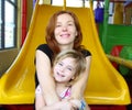 Daughter and mother together in playground slide