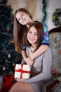 Daughter and mother under Christmas tree Royalty Free Stock Photo