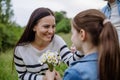 Daughter picking flowers, giving them to mother. Concept of family ecological hobby in nature. Mother& x27;s Day.