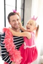 Daughter in pink dress and crown laughing with daddy