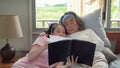 The daughter reads to an elderly mother until she fell asleep in bed. The warmth of love within the family