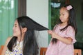 Daughter`s is combing mother hair after bathing Royalty Free Stock Photo