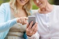 Daughter and senior mother with smartphone at park Royalty Free Stock Photo