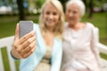 Daughter and senior mother taking selfie at park Royalty Free Stock Photo
