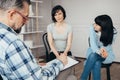 Daughter sits next to her mother during a meeting with therapists for teenagers with problems