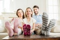 Daughter sitting with hugging parents on sofa at home Royalty Free Stock Photo