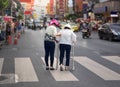 Daughter take care elderly woman crossing the street in Chinatown area Royalty Free Stock Photo