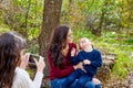 Daughter taking mobile photo mother and son