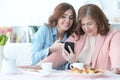 Daughter teaches an elderly mother to use a mobile phone