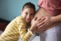 Daughter touching the belly of her pregnant mother Royalty Free Stock Photo