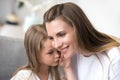 Daughter whispering to moms ear a secret Royalty Free Stock Photo