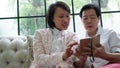 Daugther teaching mother to use smart phone for social media at