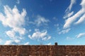 a daunting high brick wall under a clear sky