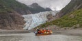 Tourists, a guide sailing in canoe to glacier Royalty Free Stock Photo