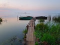 Dawn begins. Wooden Pier for Boats on the Lake Shore Royalty Free Stock Photo