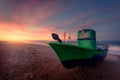 Dawn behind a boat located on the shore of the beach