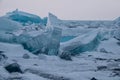 Dawn in the blue hummocks of ice lake baikal, in a snowy field i