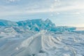 Dawn in the blue hummocks of ice lake baikal, in a snowy field i