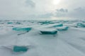 Dawn in the blue hummocks of ice lake baikal, in a snowy field in winter on a journey