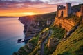 dawn breaking over an ancient fortress on cliff