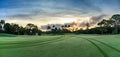 Dawn breaks over the golf cart paths along the grass of a golf course Royalty Free Stock Photo