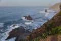 Dawn breaks over a tranquil coast with rocky cliffs and undulating waves, creating a peaceful seascape