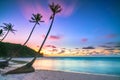 Dawn on a deserted beach with beautiful leaning coconut trees facing the sea Royalty Free Stock Photo