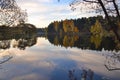 Dawn in the forest near the lake. The forest is reflected in the water. Autumn Early morning. Russia Royalty Free Stock Photo