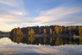 Dawn in the forest near the lake. The forest is reflected in the water. Autumn Early morning. Russia Royalty Free Stock Photo