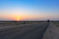 Dawn light in desert sky with empty road passing through the desert. Wind mills in the horizon, Sun rise at Thar desert, Rajasthan