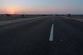 Dawn light in desert sky with empty road passing through the desert. Wind mills in the horizon, Sun rise at Thar desert, Rajasthan