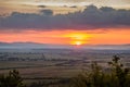 Dawn in the mountains. The sun rises from behind the mountains. Beautiful green hills and green valley. Little sleeping town. A Royalty Free Stock Photo