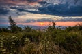 Dawn in the mountains. The sun rises from behind the mountains. Beautiful green hills and green valley. Little sleeping town. A Royalty Free Stock Photo