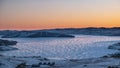 Dawn over a frozen lake. The sky above the ridge is colored orange. Royalty Free Stock Photo