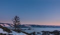 Dawn over a frozen lake. The sky and the mountain range are highlighted in pink. Royalty Free Stock Photo