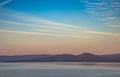 Dawn over the lake in the old mountains of the southern Urals. Fog above the water and among the wooded hills, colored Royalty Free Stock Photo