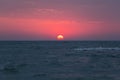 Dawn over the sea, the red sun rises above the horizon Royalty Free Stock Photo