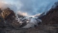 Dawn panoramic view of the Big Aktru Glacier, high in the mountains, covered by snow and ice. Dramatic Altai winter landscape