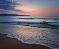Dawn at the sea with foamy waves on the sand and colorful sky at the horizon. Sunny Beach coastline in Bulgaria. Summer and travel Royalty Free Stock Photo
