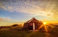 Dawn on the shore of the Atlantic Ocean. A traditional old house with a roof overgrown with grass and a tent on the beach. Iceland Royalty Free Stock Photo