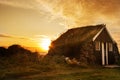 Dawn on the shore of the Atlantic Ocean. A traditional old house with a roof overgrown with grass and a tent on the beach. Iceland Royalty Free Stock Photo