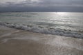 Dawn with stormy sky over the silver ocean. Lone fisherman boat in the water.