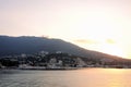 Dawn of the sun on the sea, in the port of the city of Yalta, with a view of the houses and mountains. Crimea, Ukraine, background