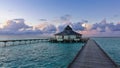 Dawn. A wooden walkway runs over the calm aquamarine ocean. Royalty Free Stock Photo