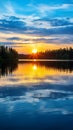 Sunrise over lake with rays of sunlight piercing through blue clouds and reflecting on the rippled water surface Royalty Free Stock Photo