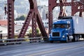 Day cab blue big rig semi truck transporting commercial cargo in Royalty Free Stock Photo