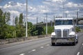 Day cab white big rig semi truck tractor without semi trailer running on the road to warehouse for trailer pick up Royalty Free Stock Photo