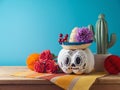 Day of the dead holiday concept. Sugar skull Halloween pumpkin and Mexican party decorations on wooden table over blue background Royalty Free Stock Photo