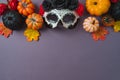 Day of the dead Mexican and Halloween holiday concept. Sugar skull mask, pumpkin and party decorations on purple background. Top Royalty Free Stock Photo